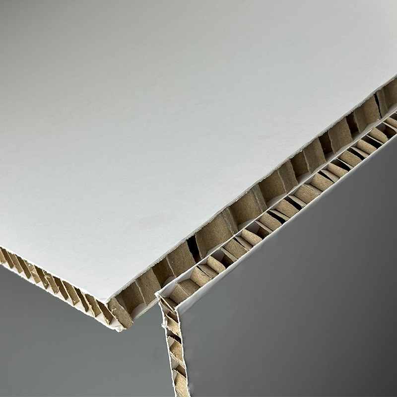 Panneau composite en carton alvéolaire avec des surfaces blanches et une structure nid d'abeille. Produit écologique totalement et facilement recyclable